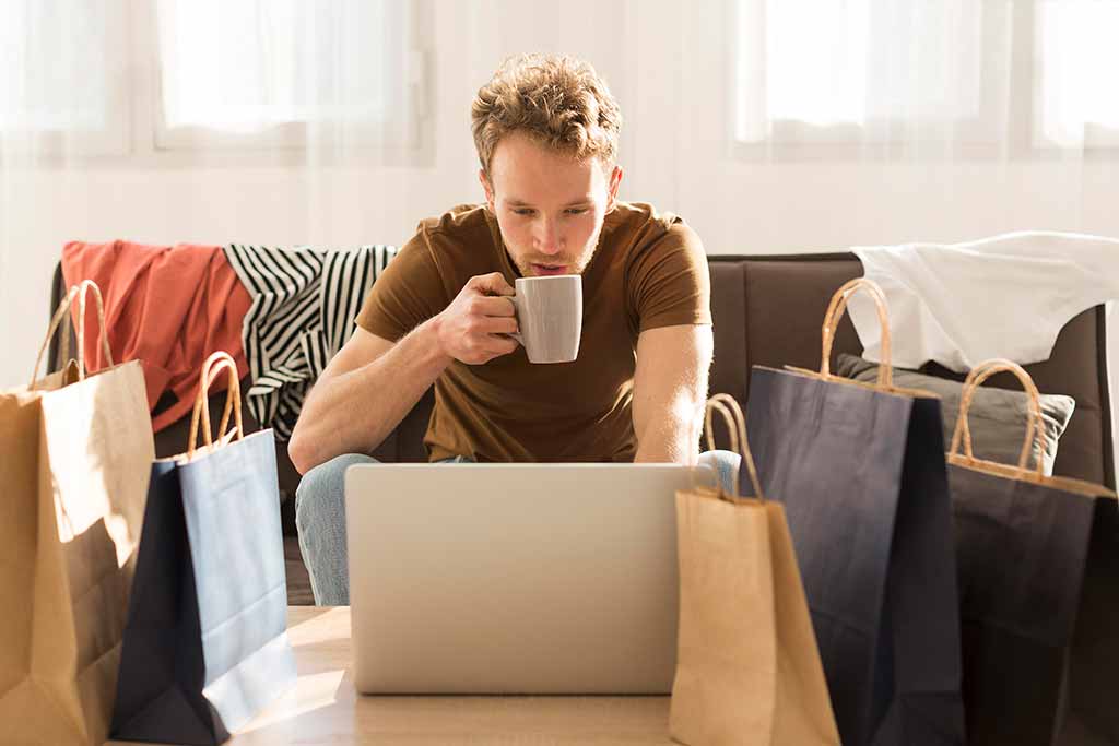 Cómo vender por Internet con el mejor hosting y dominio. Hombre trabajando sentado en un sofá